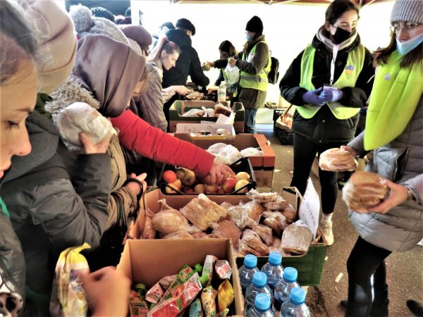 野菜や飲料物などを手にする難民の人々